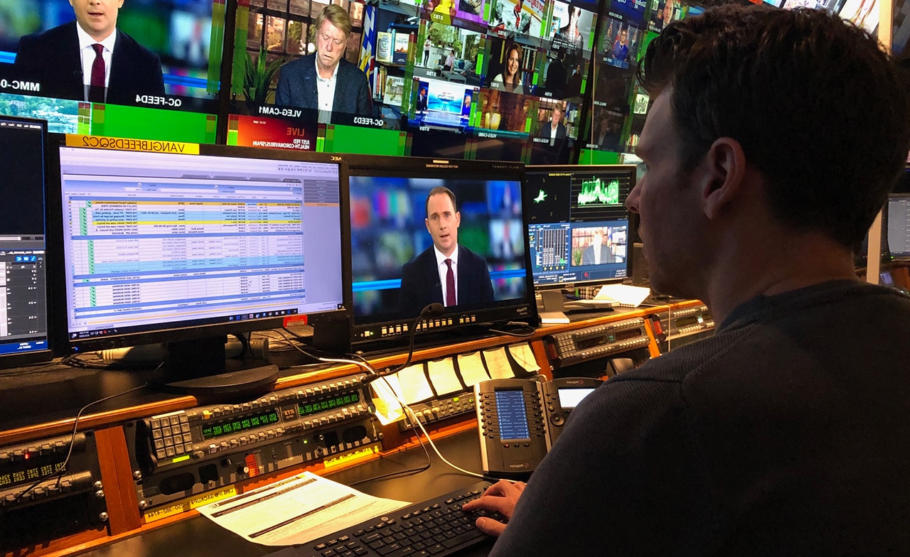 Person in broadcast studio looking at monitors