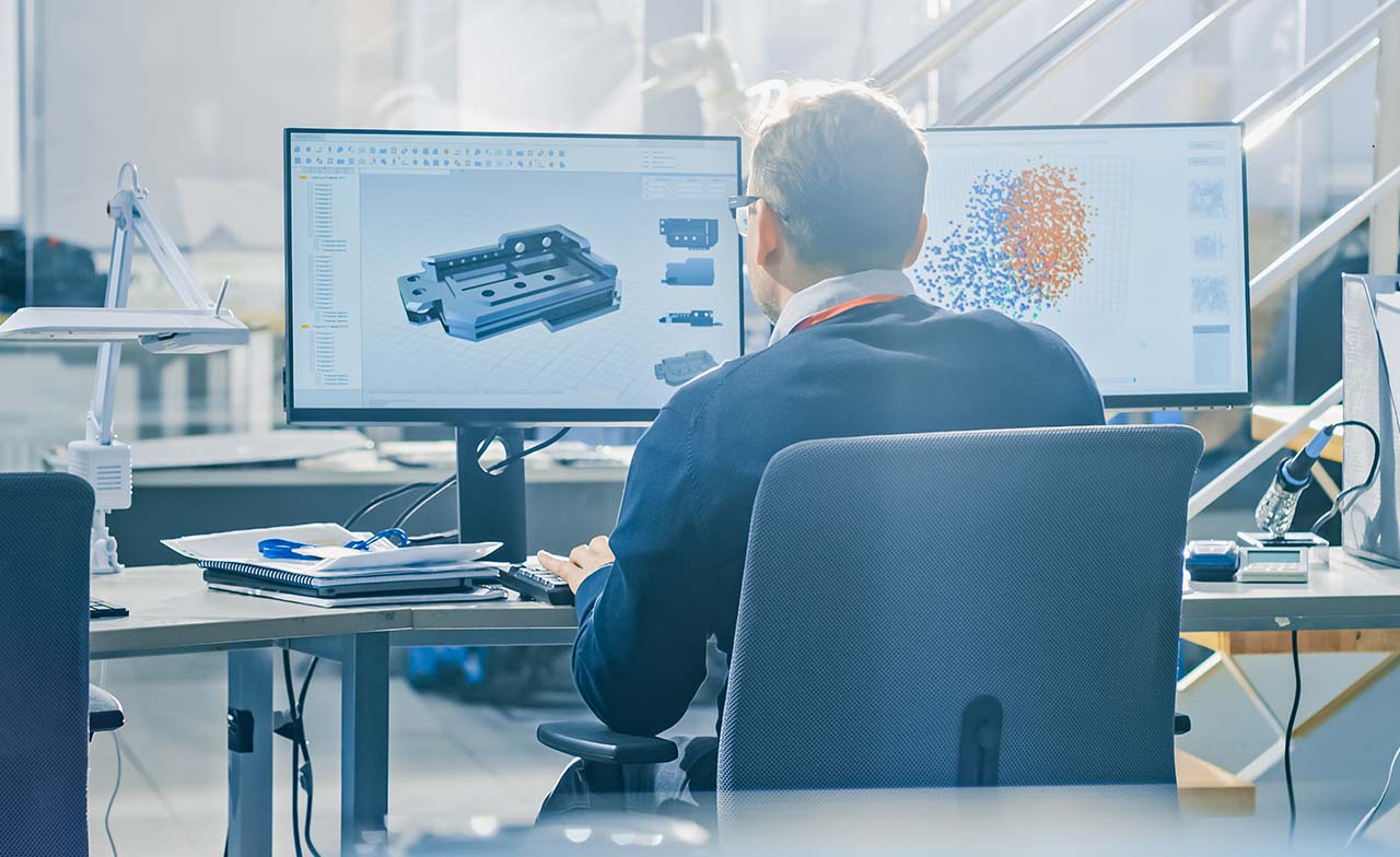 Man looking at information on multiple screens