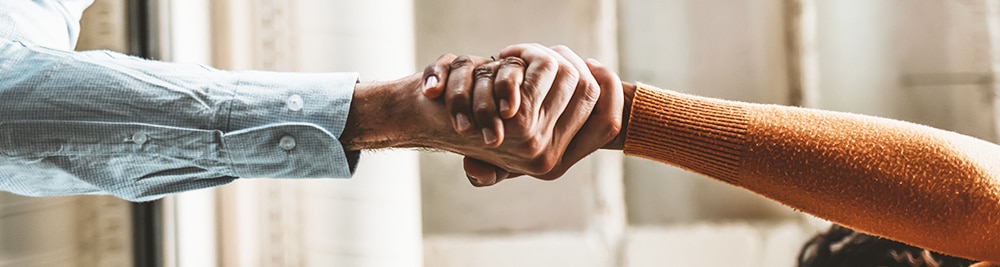 Trust_Handshake 2 people extending their arms to hold hands