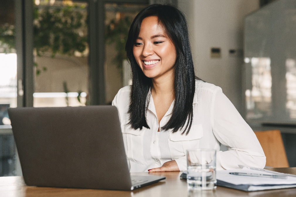 Smiling professional sitting at desk with laptop