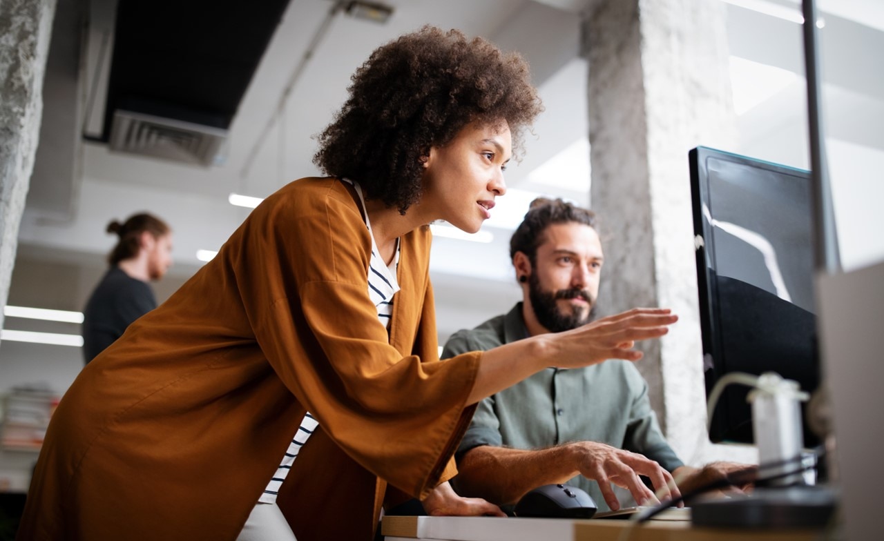 two employees discussing in front of a computer