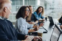 smiling people having a meeting around the table