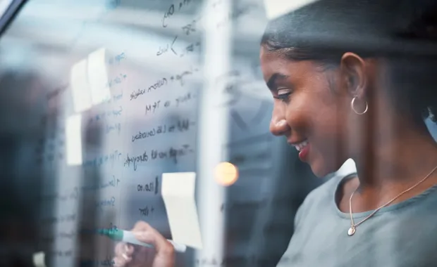 Engineer working out code on a whiteboard