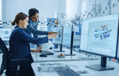 Colleagues in technical setting looking at SAP S/4HANA on computer screen