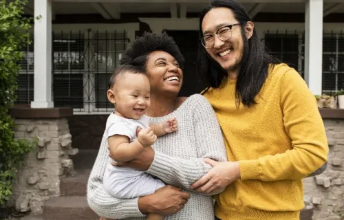 family stnading in front of house
