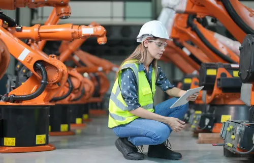 Female engineer working at AI robotic factory