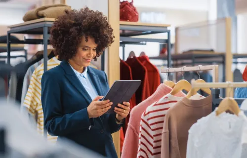 female merchandising manager uses tablet to check inventory