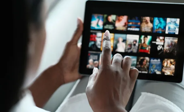 Woman selects her favorite movie on tab screen