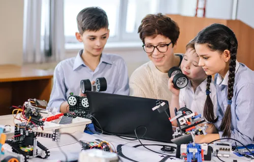 Adult and kids looking at a computer