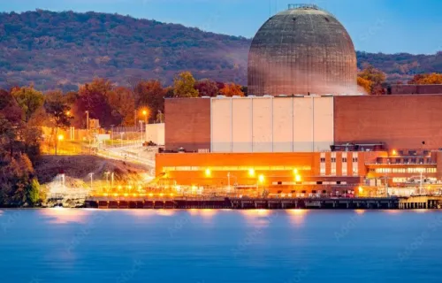 Nuclear reactor next to river seen in the evening with lights shining