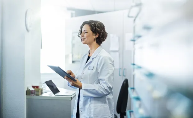 health professional smiling with tablet in her hand