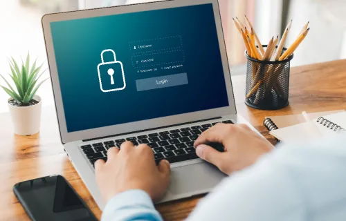 A person types on a laptop displaying a secure login screen, reflecting efforts to strengthen…