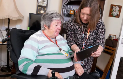Social care worker showing patient something on tablet device